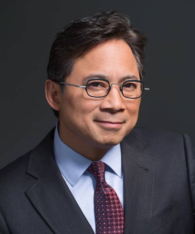 Professional photo of Dr. William Li, expert on anti-inflammatory foods, in suit and tie